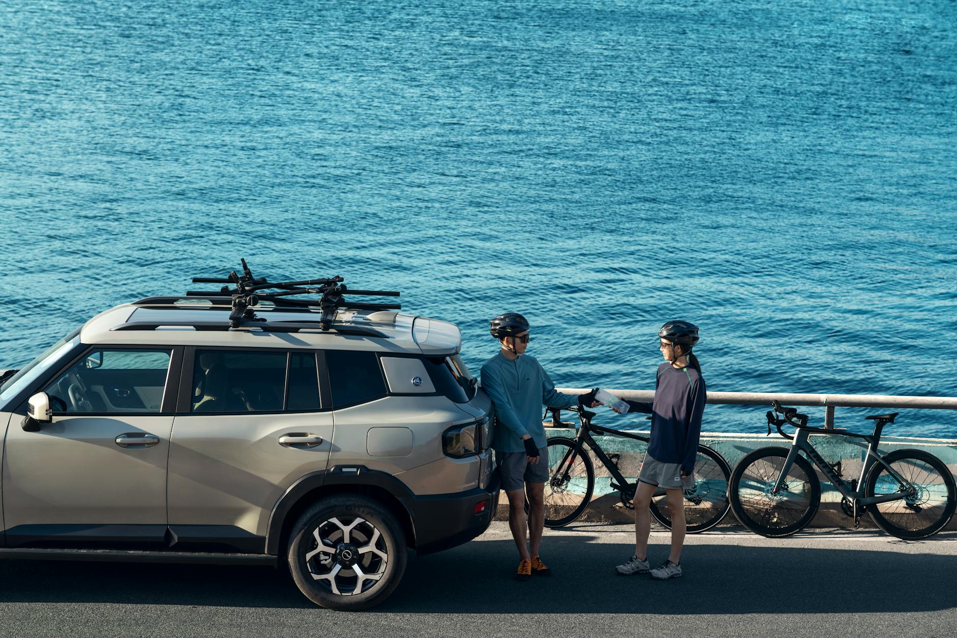 Rowerzyści przy załadowanym SUV-em nad błękitnym oceanem