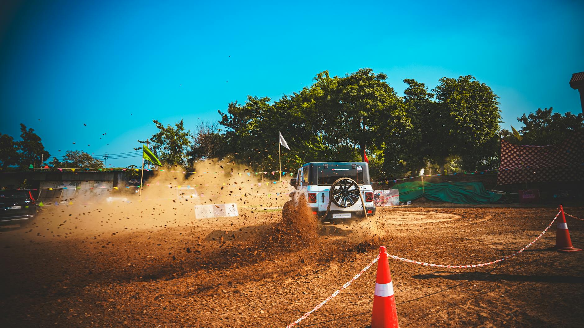 Toyota Land Cruiser jadący w terenie, wzbijający kurz podczas off-roadu