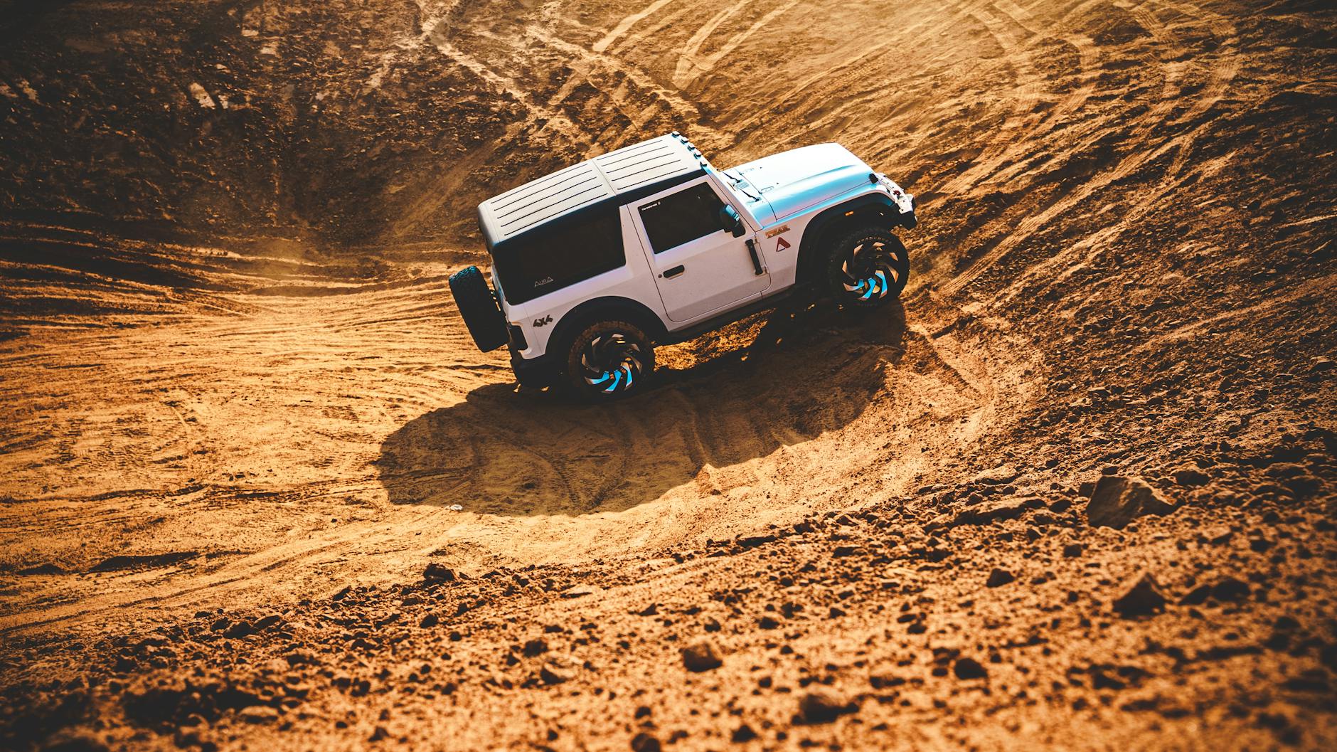 Toyota Land Cruiser jedzie dynamicznie po piaszczystych wydmach