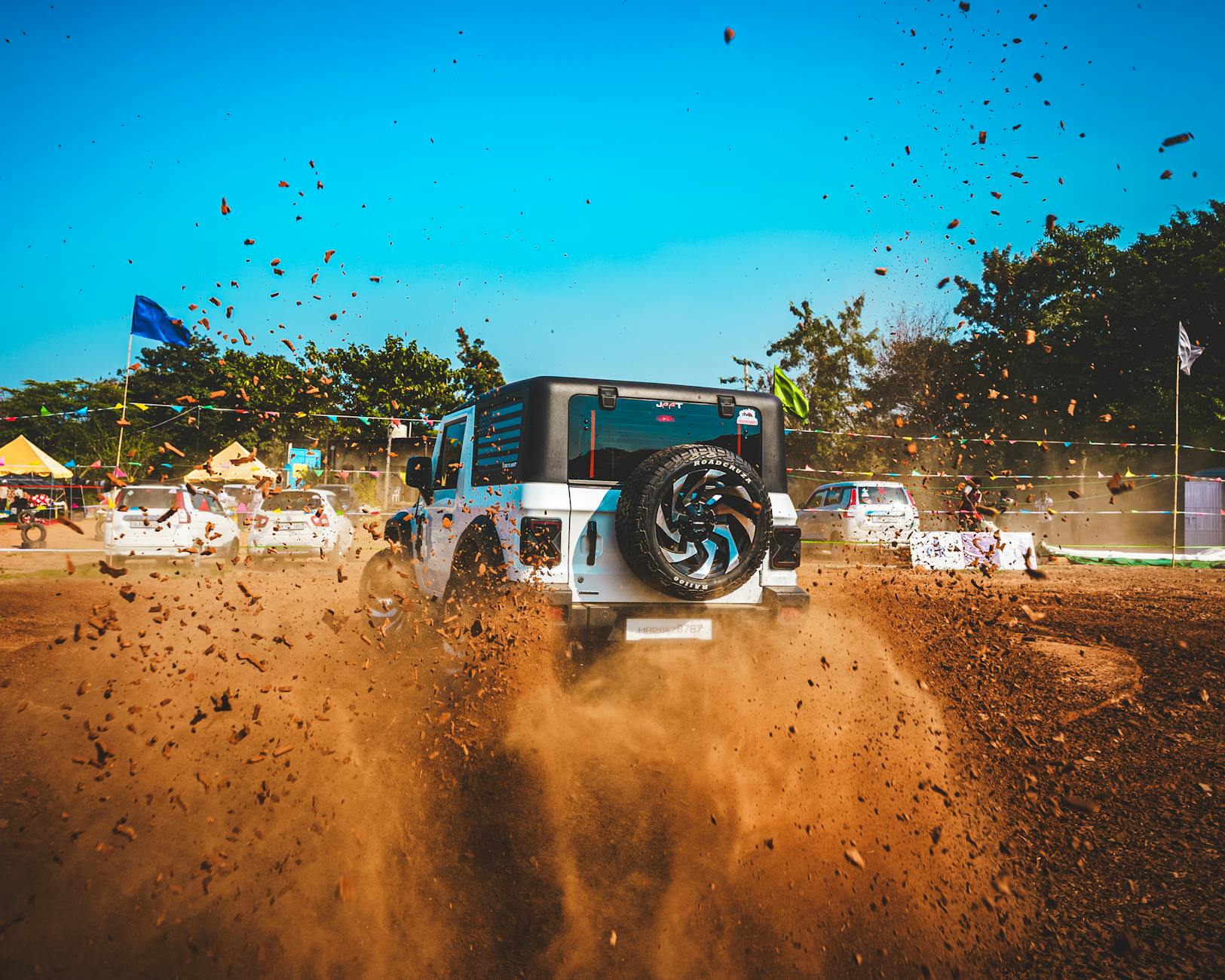 Toyota Land Cruiser jedzie po kurzącej się, piaszczystej off-roadowej drodze