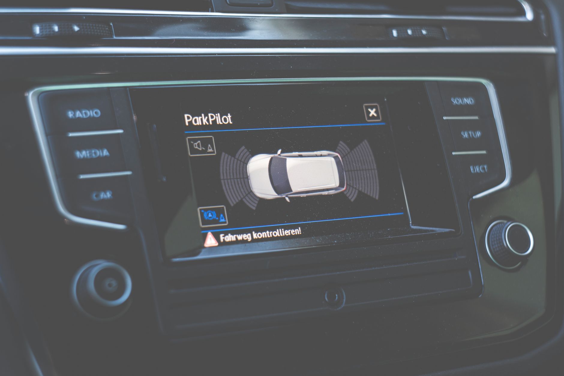 Zbliżenie na ekran ParkPilot z asystentem parkowania w Volvo dashboard