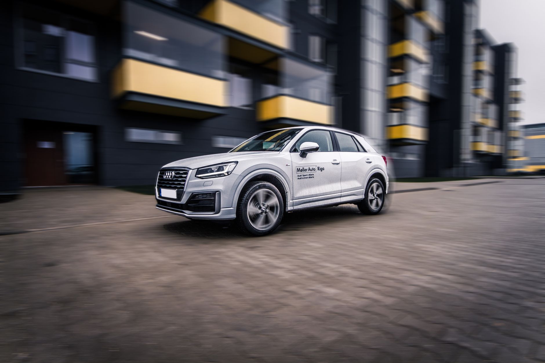 Nowoczesny SUV Audi pędzący przez współczesne centrum miasta