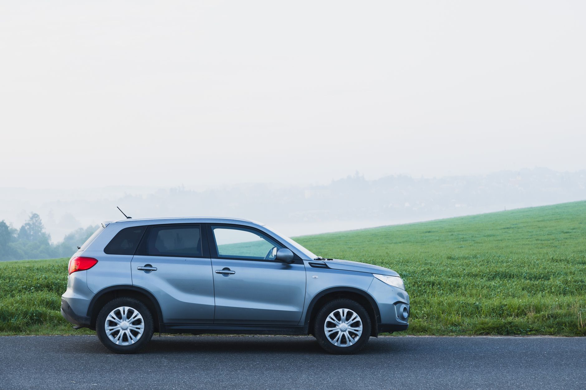 Srebrna Toyota C-HR zaparkowana na mglistej wiejskiej drodze